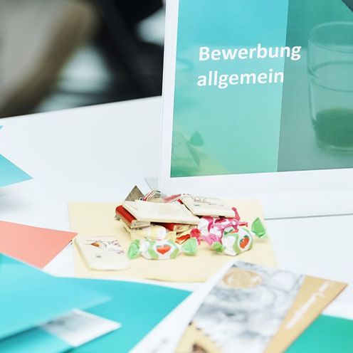 Bewerbungsmappen liegen auf einem Tisch.