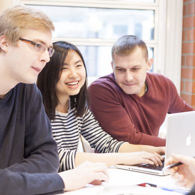 Eine Gruppe Studierender lernt und diskutiert gemeinsam in der Mensa.