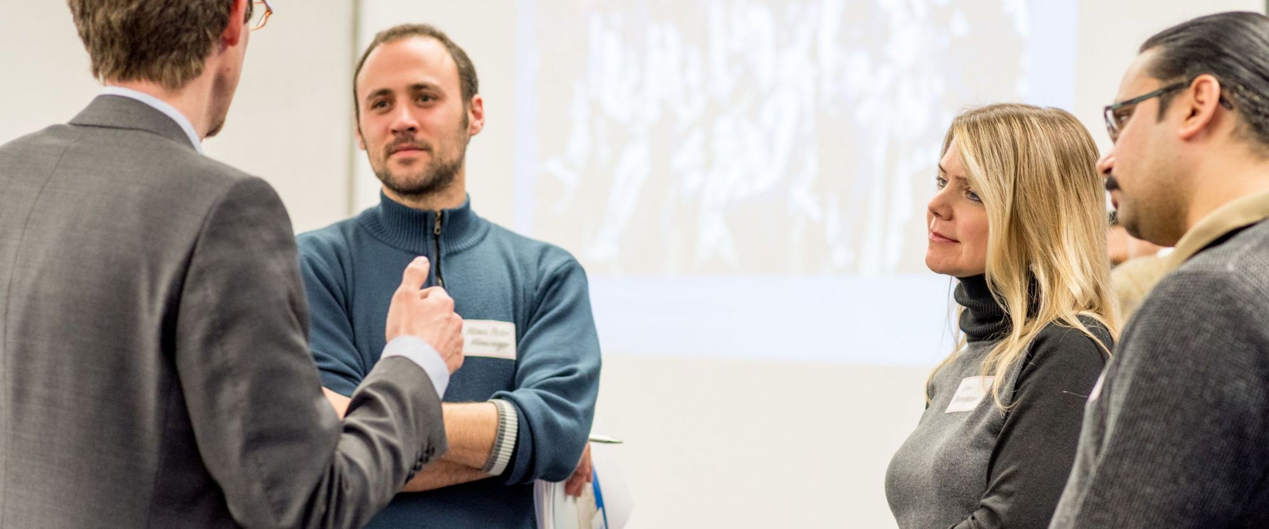 Ein Unternehmensvertreter diskutiert mit einer Gruppe Studierender.