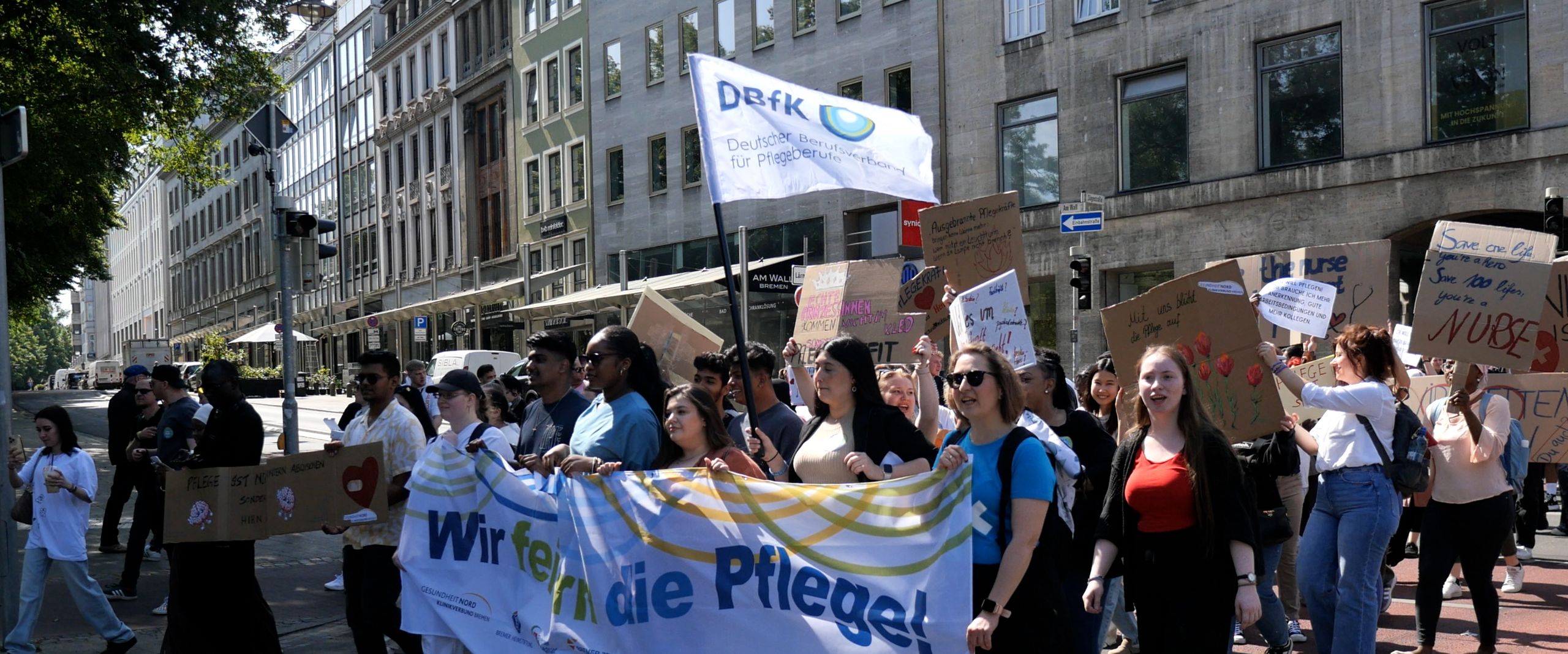 Menschen halten gro&szlig;e Transparente und laufen zusammen in einem Deomonstrationszug