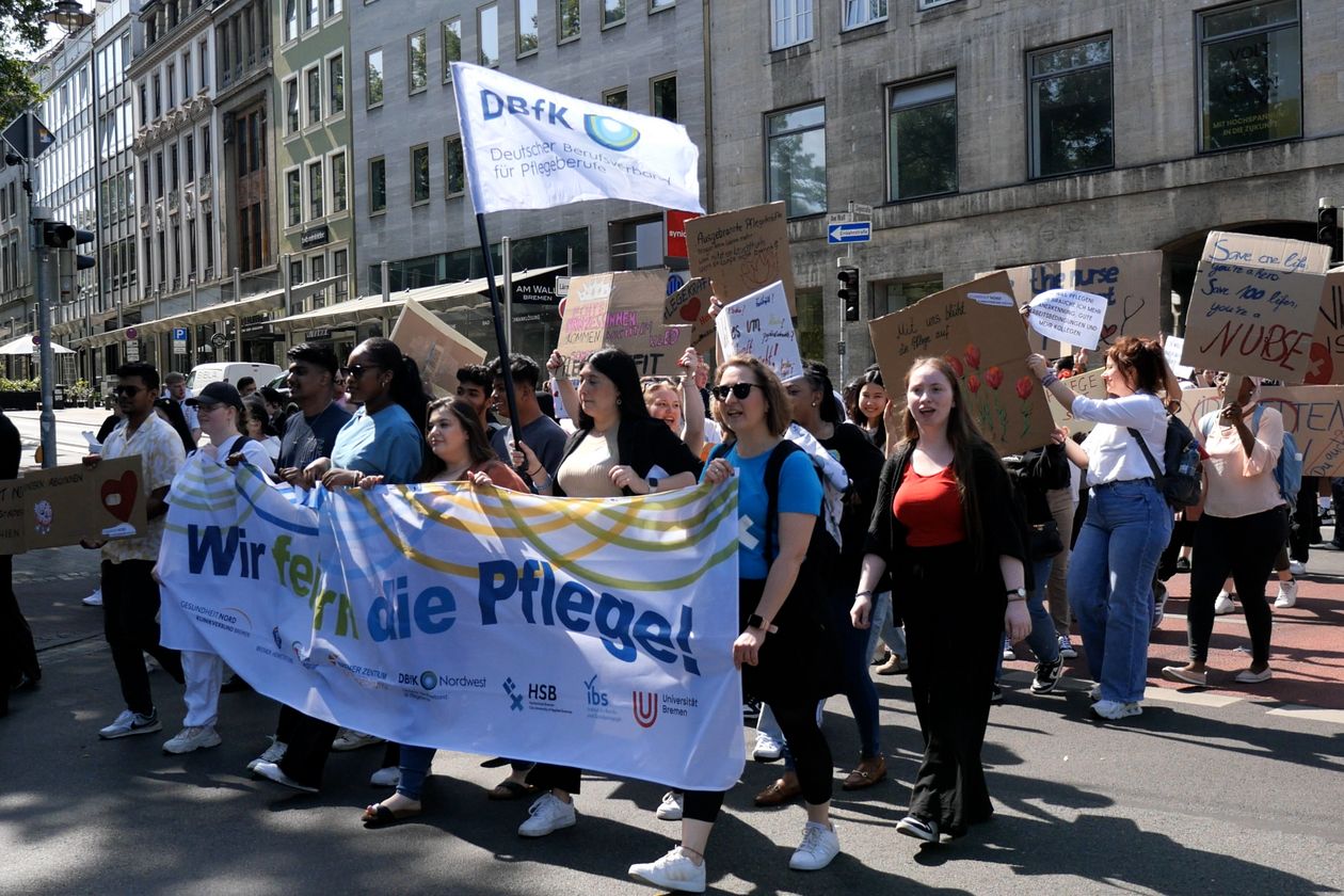 Menschen halten gro&szlig;e Transparente und laufen zusammen in einem Deomonstrationszug