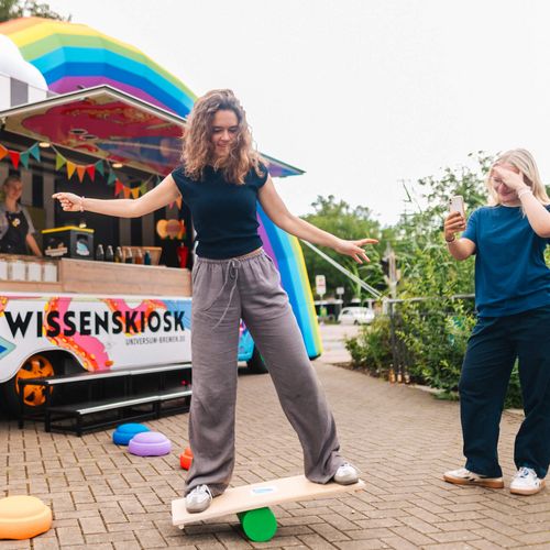 Bunter Kiosk. Davor sind zwei Menschen aktiv