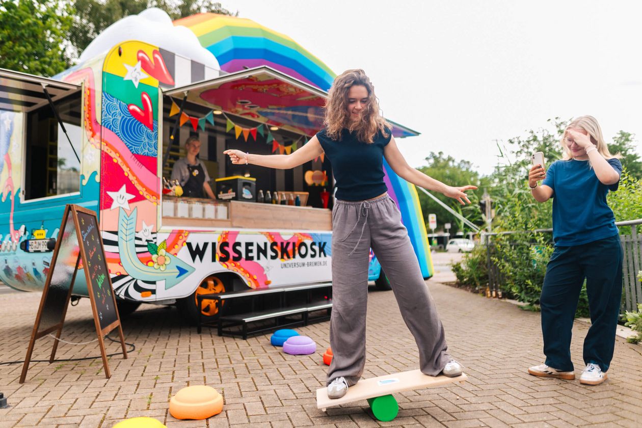 Bunter Kiosk. Davor sind zwei Menschen aktiv