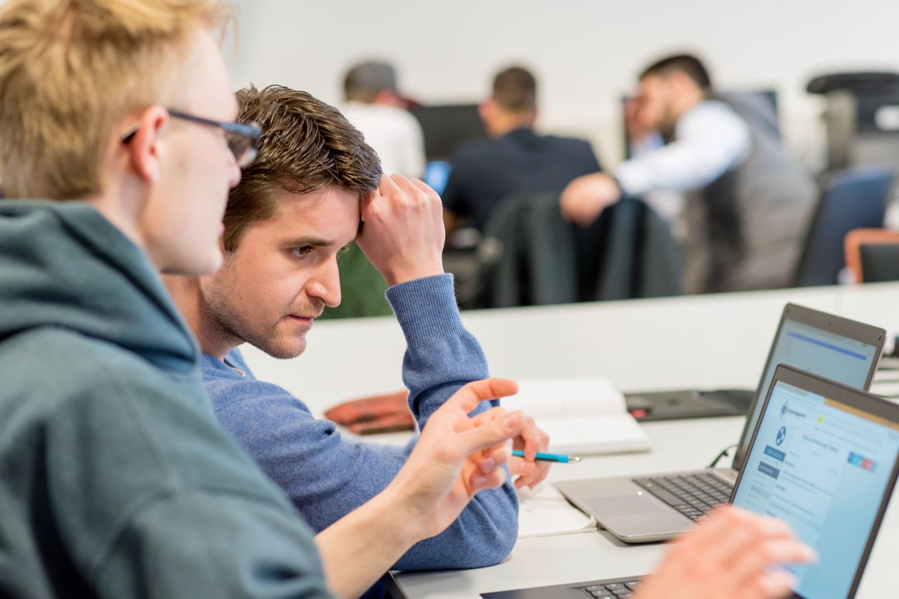 Zwei Studenten sehen sich etwas an einem Laptop an.