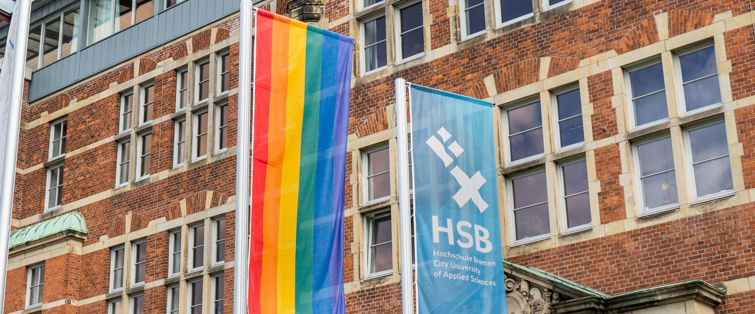 Regenbogenflagge Eine Regenbogenflagge neben der HSB-Flagge.