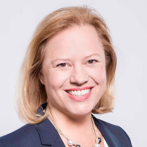 Portrait einer Frau mit wei&szlig;er Bluse und Jacket mit blonden schulterlangen Haaren.