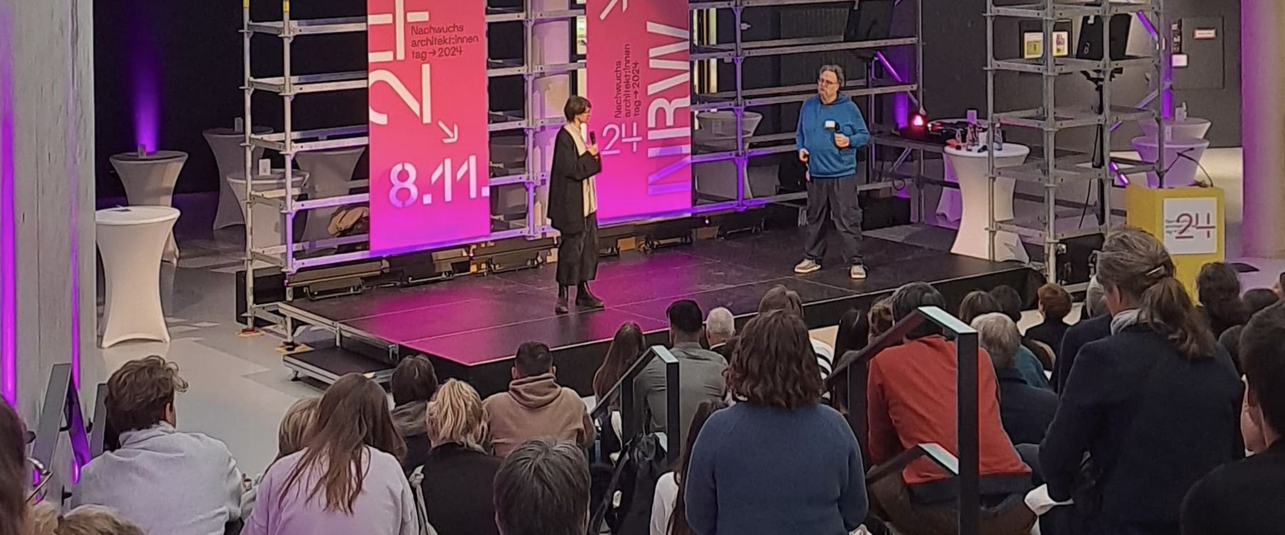 Bühne mit großem Banner vor Publikum