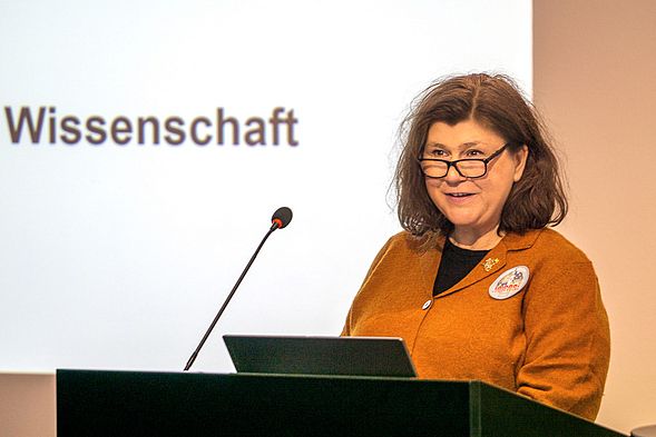 20240212_Auftakt Forschungs- und Transferschwerpunkt Luft- und Raumfahrt  Frau mit Brille hält Rede am Podium
