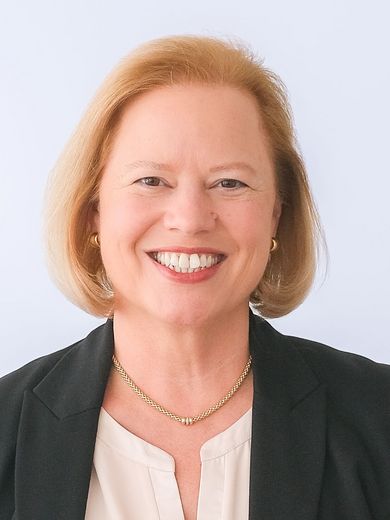 Auf dem Foto ist Wiebke Scharff-Rethfeldt zusehen. Sie hat kinnlanges blondes Haar und trägt eine weiße Bluse unter einem schwarzen Blazer. 