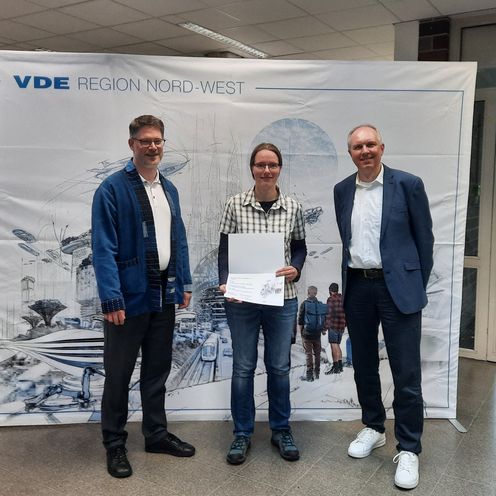 gruppenbild mit einer Frau und zwei M&uuml;nnern. Die frau h&auml;lt eine Urlunde in die Kamera