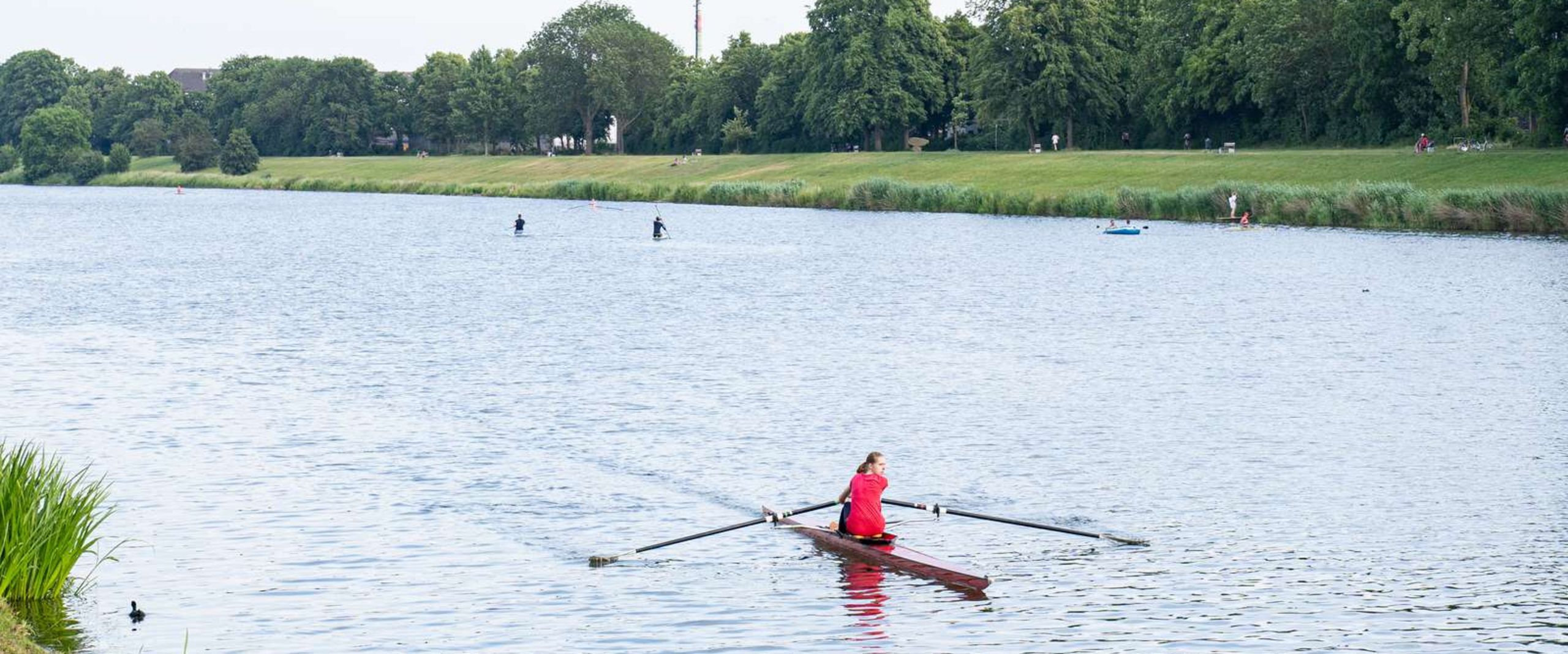 Auf dem Bild ist eine Person in einem Ruderboot auf der Weser zusehen. 