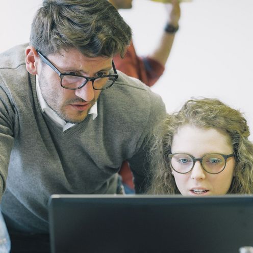 M&auml;nnliche und weibliche Person arbeiten an Laptop 