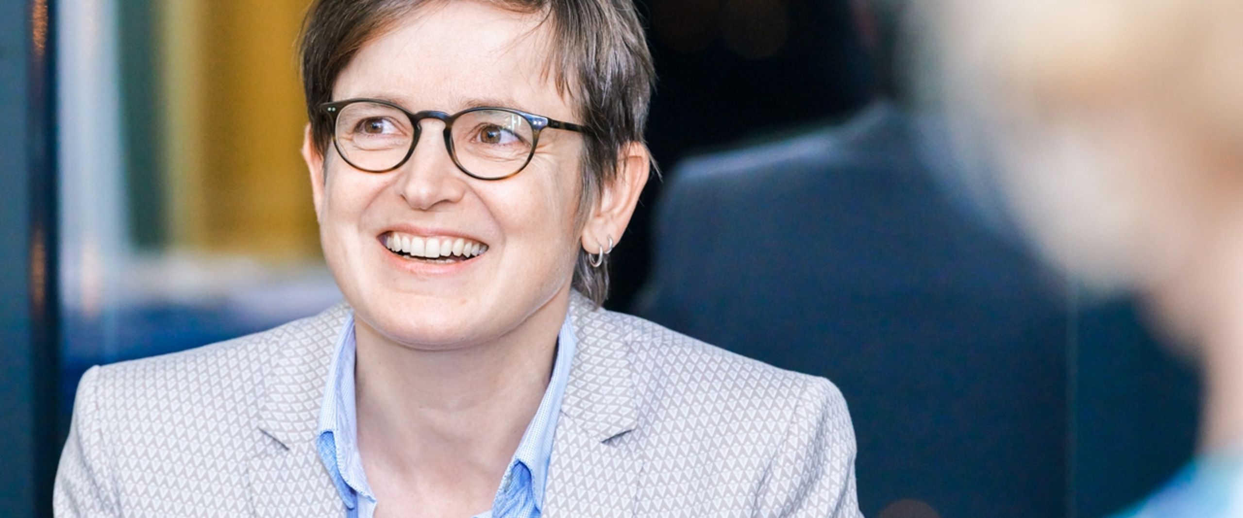 Britta L&uuml;der bei Event Karriereweg FH-Professur, sie blickt an der Kamera vorbei, freudiger Gesichtsausdruck.