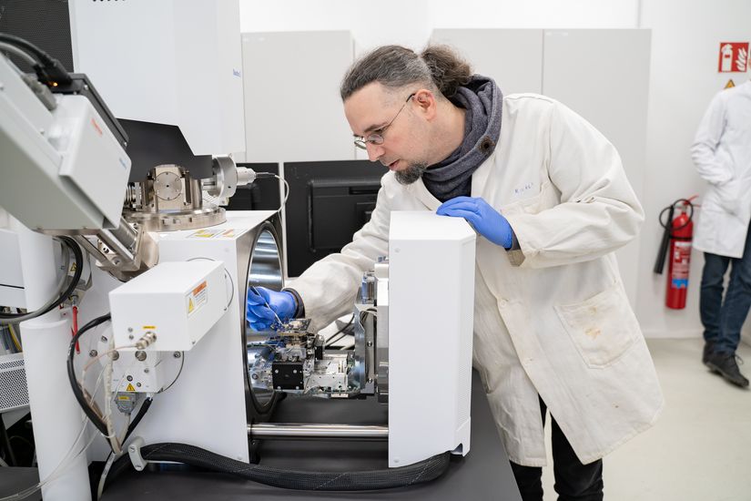 Mann steht an Ger&auml;t und legt eine Probe ein