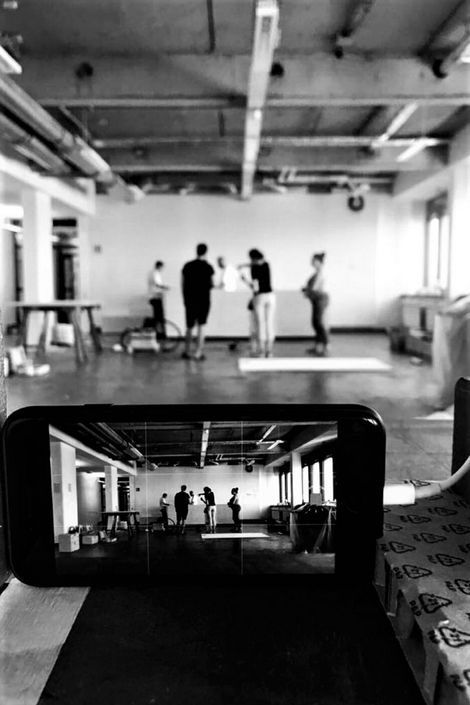 Ein Smartphone nimmt eine Gruppe von Studierenden in einem Raum auf.