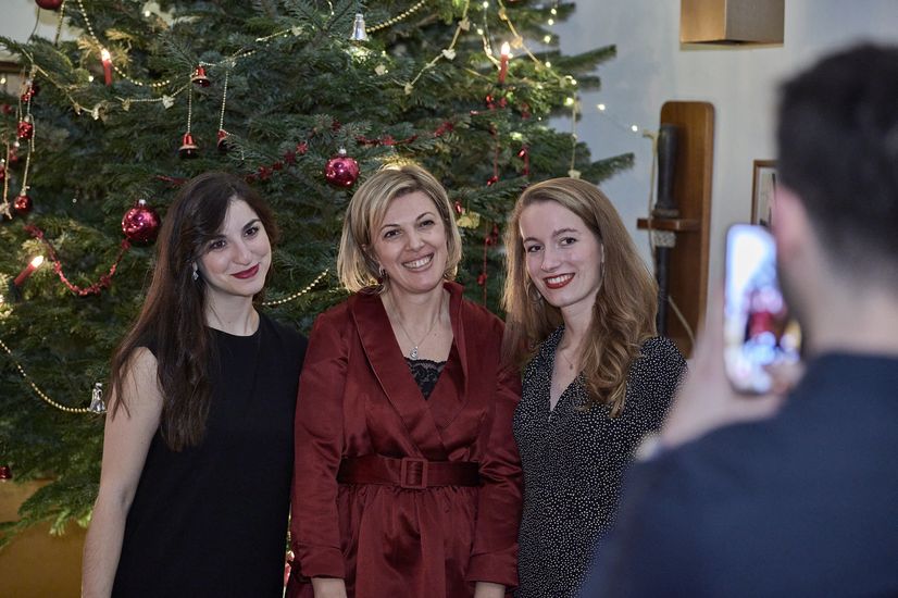 Studierende posieren vorm Weihnachtsbaum