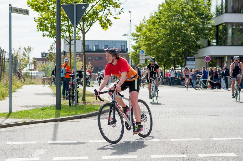 Eine Fahrradfahrerin f&auml;hrt um eine Kurve.