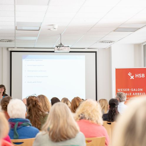 Zuschauer h&ouml;ren sich einen Impulsvortrag einer Rednerin an